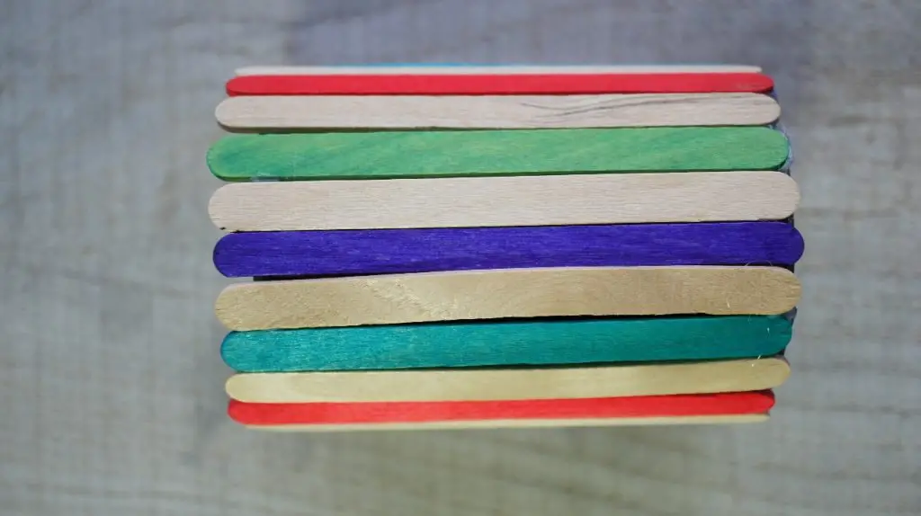 tin can covered in popsicle sticks