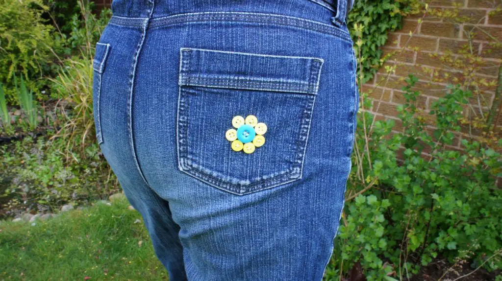 jeans rear pocket decorated with button flower yellow