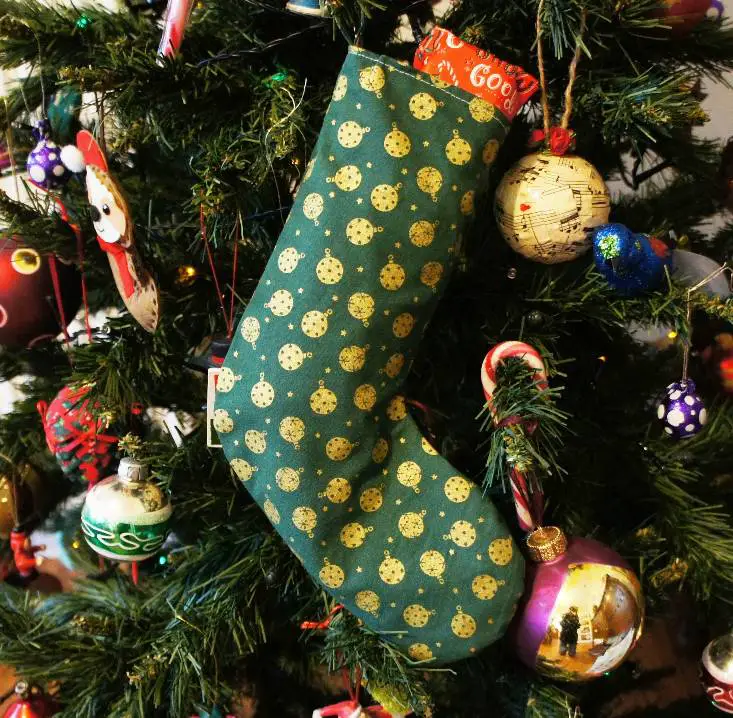 green xmas stocking on christmas tree