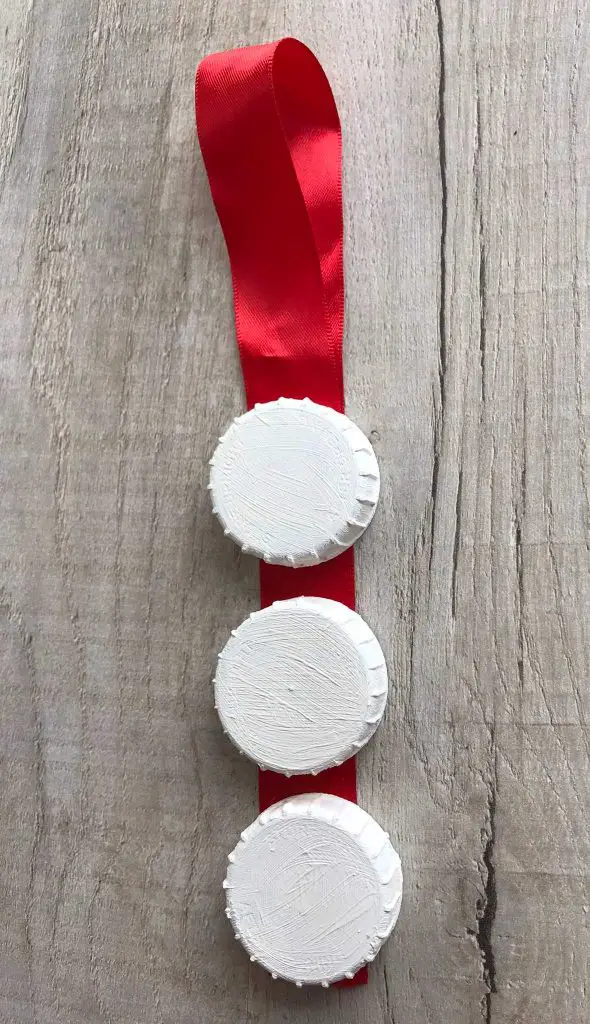 painted bottle tops on ribbon with loop