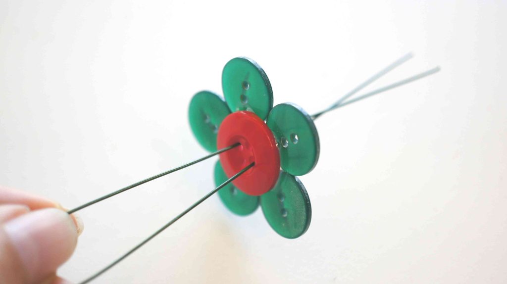 wire being inserted through button flower