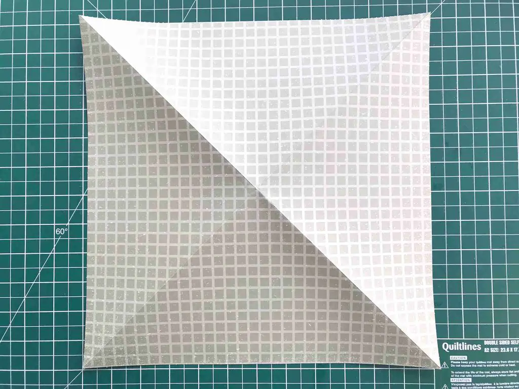 initial origami folds on square of paper
