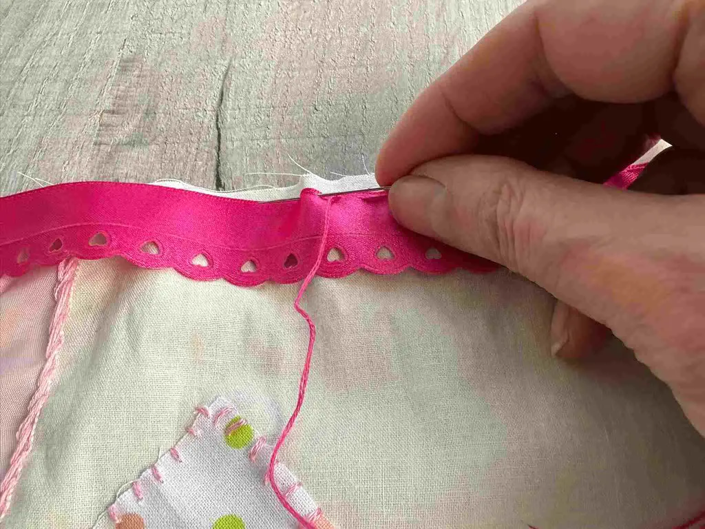 slow stitching pink ribbon in place